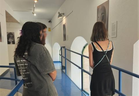 Tres jóvenes observan una de las obras expuestas en La Gota de Leche